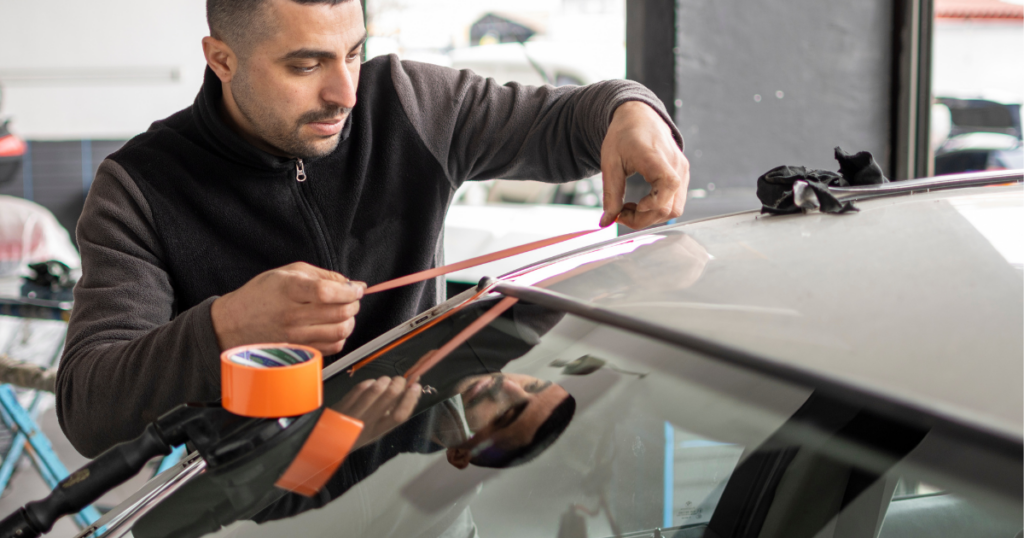 Auto glass technician fixing rear window